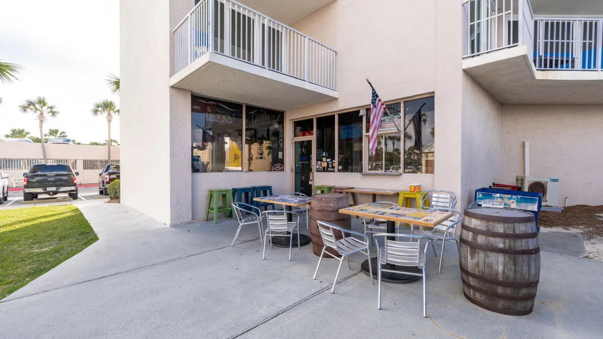 An inviting outdoor seating area with colorful chairs and barrel tables, perfect for casual al fresco dining or drinks with friends. The friendly, laid-back atmosphere encourages gathering and social connection after a day of exploring or lounging by the pool.